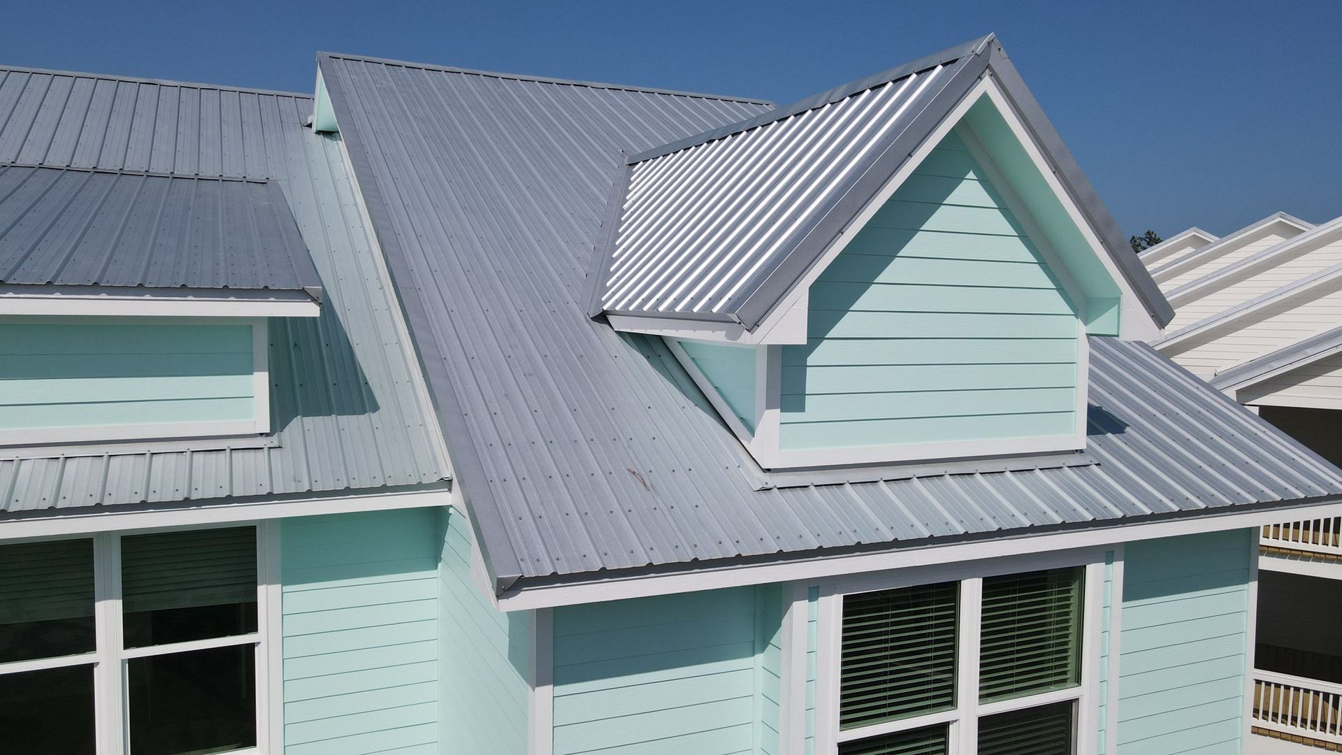 Waterfront townhomes with silver standing seam metal roofs
