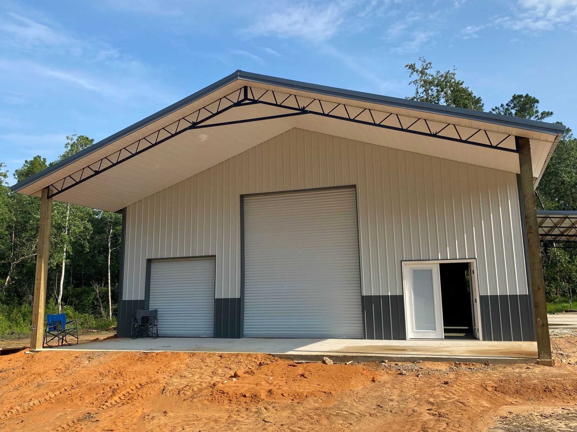 Metal pole barn with roll-up doors and a covered side bay